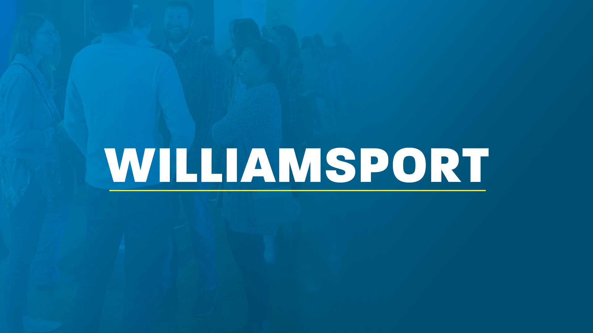 Four young people smiling together in front of the words ‘Penn State,’ written in white and underlined in yellow